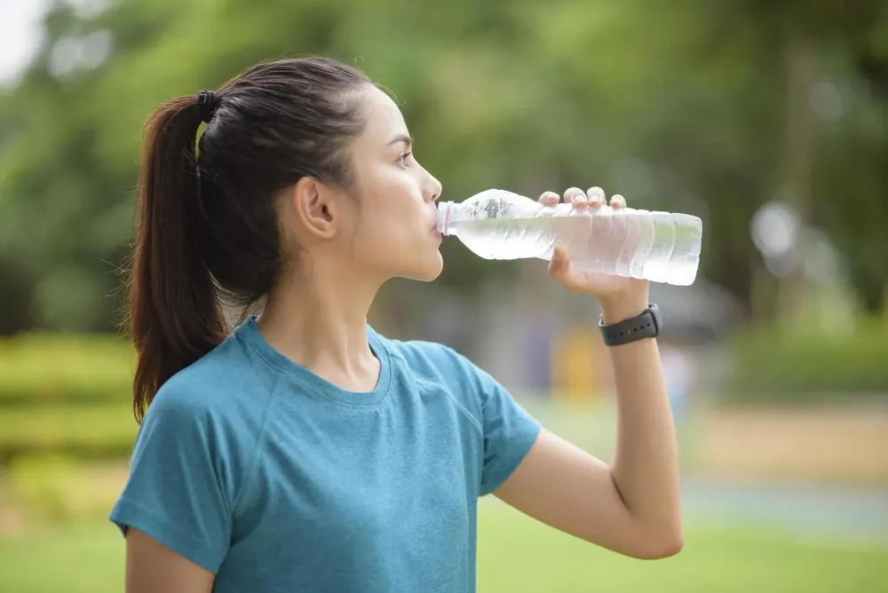 woman-drinking-water-after-workout-in-a-park-free-photo